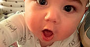 Liam joined the competition — help win amazing prizes! baby, blanket, child, close_up, curious, cushion, cute, expression, eyes, face, head, home, indoors, infant, pajamas, person, portrait, skin, soft_lighting, young