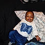 Tazori is registered to the contest to win money with this photo: baby, child, smiling, sweater, blue_pants, butterfly_design, blanket, couch, indoor, happy, face, person, footwear, sock, wheel, stroller, relaxing, infant, clothing, furniture