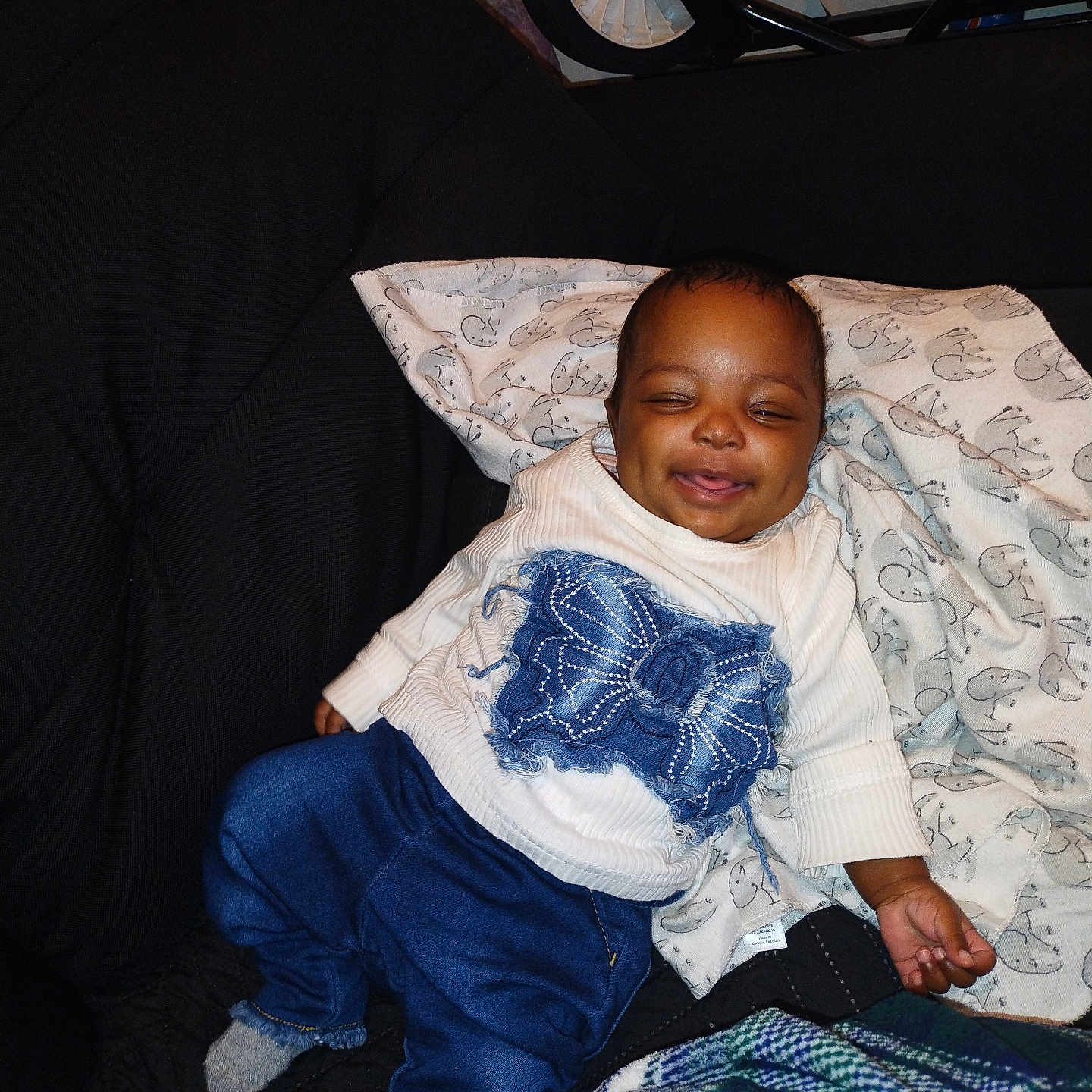 Tazori is registered to the contest to win money with this photo: baby, blanket, blue_pants, butterfly_design, child, clothing, couch, face, footwear, furniture, happy, indoor, infant, person, relaxing, smiling, sock, stroller, sweater, wheel