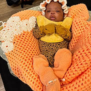 Tazori joined the competition — help win amazing prizes! baby, infant, blanket, knitwear, mittens, booties, bib, leopard_print, orange, yellow, sleepy, cute, cozy, indoor, person, child, headwear, soft, warm, resting