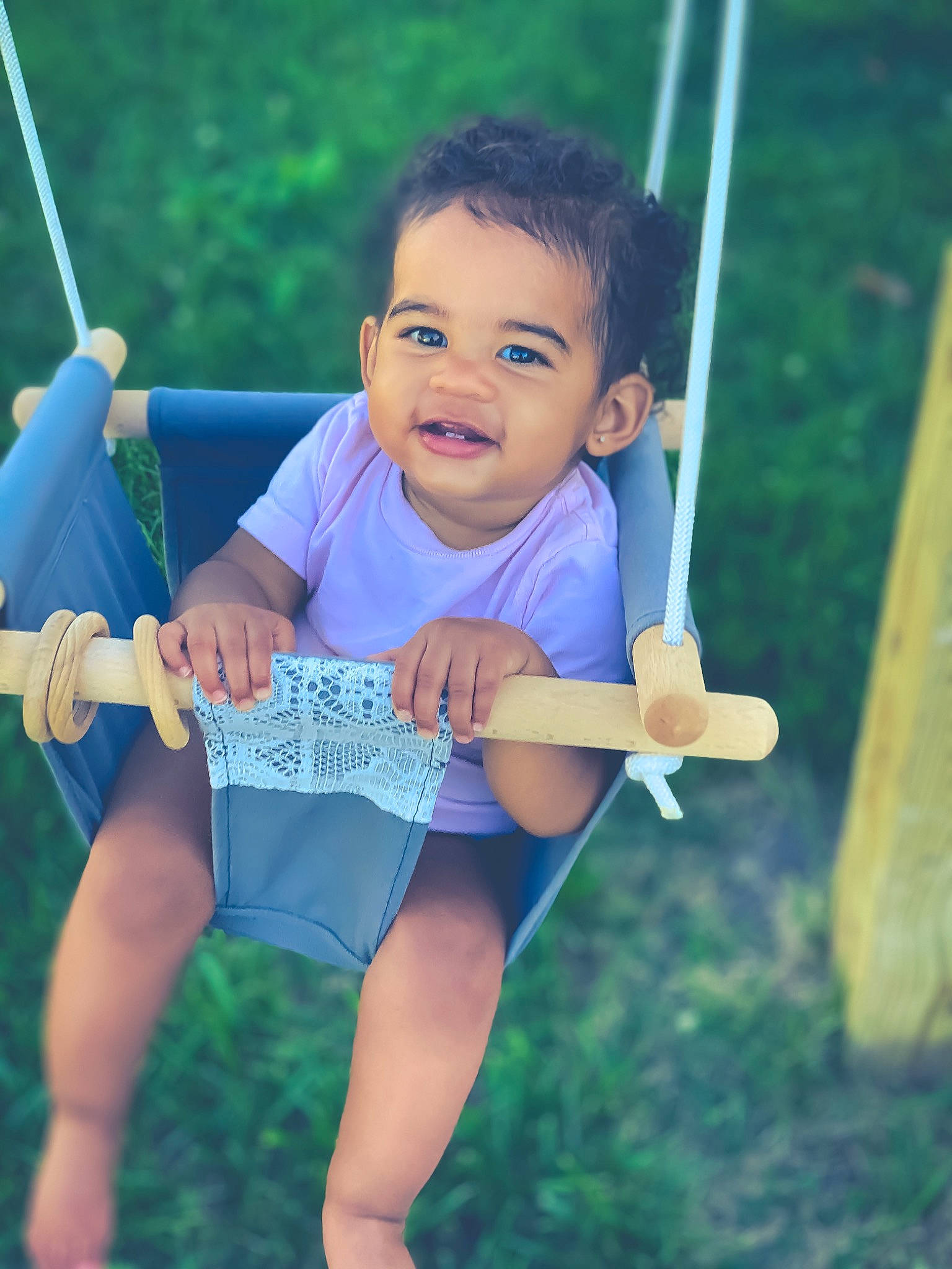 Amani is registered to the contest to win money with this photo: baby, child, facial_expression, fun, grass, happy, leisure, outdoor_play_equipment, person, play, playground, smile, summer, swing, toddler, vacation