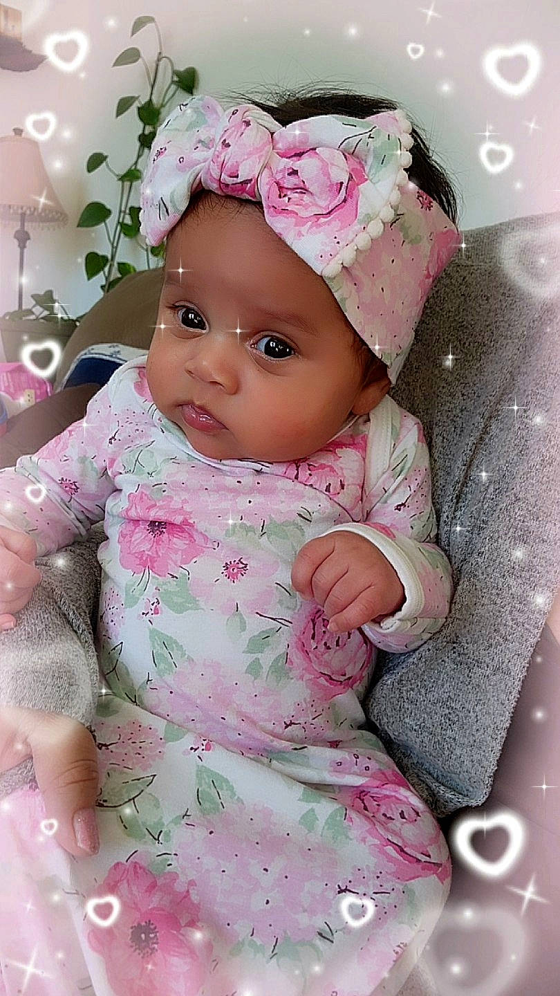 Xavianna is registered to the contest to win money with this photo: baby, baby_toddler_clothing, cap, cheek, child, dress, eye, happy, head, headgear, headwear, lip, outerwear, pattern, person, pink, product, skin, sleeve, textile