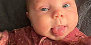 Ryker joined the competition — help win amazing prizes! baby, infant, tongue_out, onesie, floral_pattern, cute, playful, lying_down, blanket, face, skin, child, person, expression, sleepwear, young, adorable, closeup, head, baby_girl