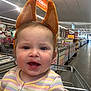 toddler, child, shopping_cart, store, aisle, animal_ears, headband, smiling, clothing, striped_sweater, flower, indoor, person, cute, baby, face, happy, retail, shopping, cart