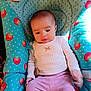 baby, baby_seat, child, clothing, comfort, cute, face, indoor, infant, pacifier, pattern, person, pink_pants, polka_dots, portrait, sitting, soft_lighting, strawberry, white_top, young_child