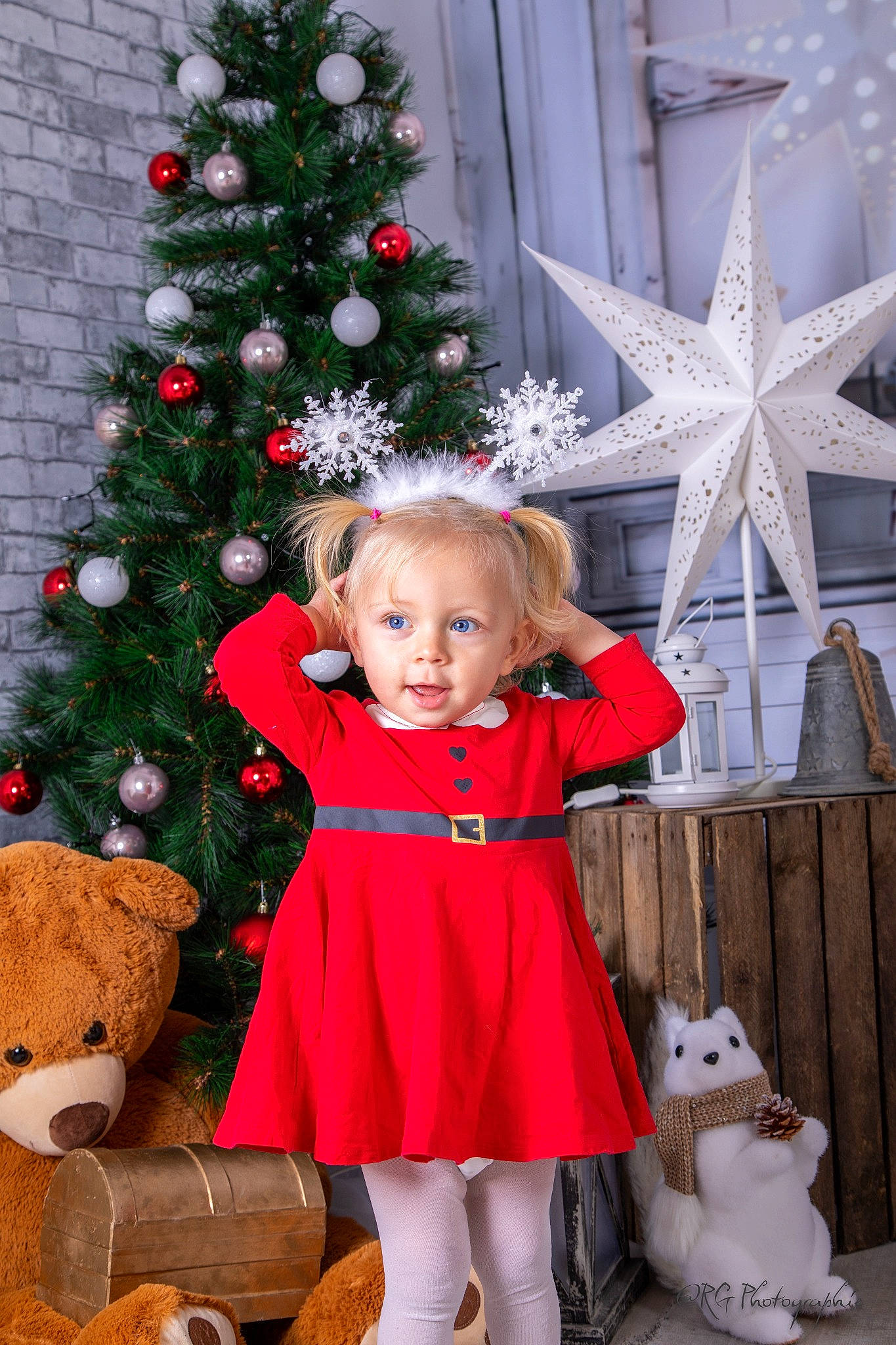 Kelly a rejoint le concours — aidez-le/la à gagner de superbes lots ! baby_toddler_clothing, christmas_decoration, christmas_ornament, christmas_tree, dress, evergreen, facial_expression, fawn, happy, holiday_ornament, human_body, ornament, people, person, photograph, pink, plant, red, standing, toddler