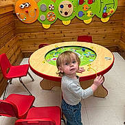 Coby joined the competition — help win amazing prizes! toddler, child, playroom, red_chair, wooden_wall, play_table, caterpillar_toy, curious, indoor, floor, jeans, long_sleeve, shoes, toy, furniture, young_child, looking_up, colorful, activity, casual_clothing