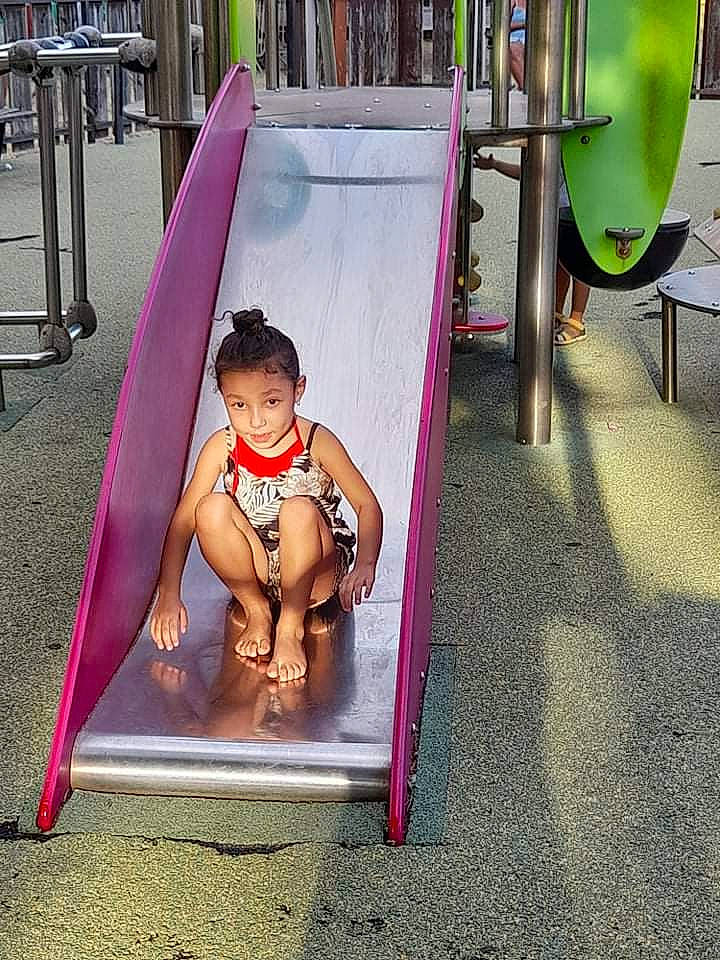 Leïla participe au concours pour gagner de l'argent avec cette photo : child, chute, city, fun, human_leg, human_settlement, leisure, magenta, outdoor_play_equipment, person, physical_fitness, pink, play, playground, playground_slide, public_space, recreation, room, sitting, thigh