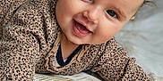 Elenna participe au concours pour gagner de l'argent avec cette photo : baby, child, smiling, happy, face, blue_eyes, sweater, patterned_clothing, hand, cushion, indoor, portrait, cute, toddler, skin, head, fingers, wooden_beams, soft_texture, closeup