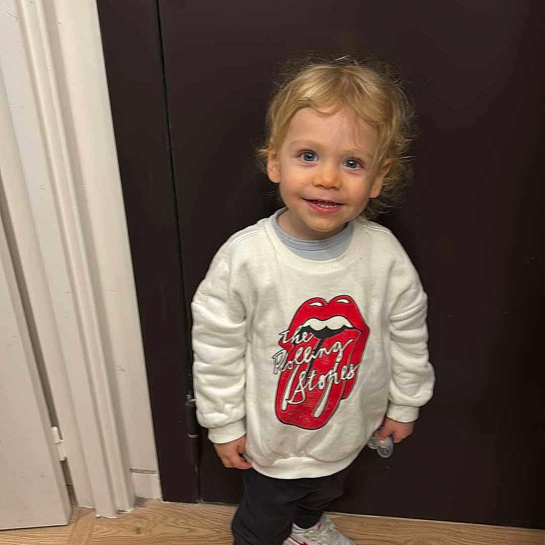 Aaron a rejoint le concours — aidez-le/la à gagner de superbes lots ! boy, child, clothing, door, face, footwear, hardwood, head, longsleeve, male, pants, person, photography, portrait, shoe, sitting, sleeve, sneaker, t_shirt, wood