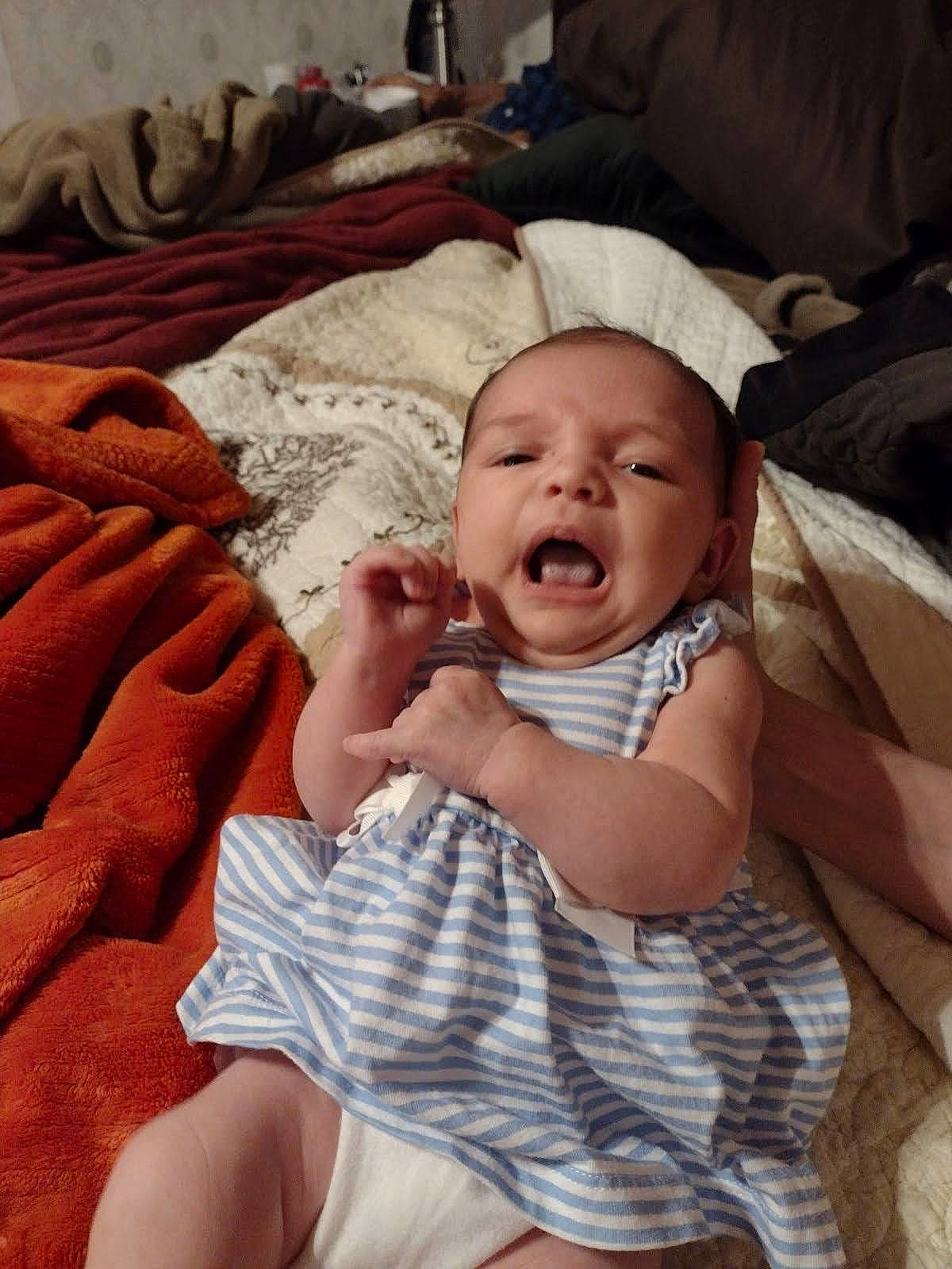 Robyn is registered to the contest to win money with this photo: baby, baby_toddler_clothing, cheek, child, comfort, eye, facial_expression, finger, fun, happy, hat, linens, mouth, nail, pattern, person, room, skin, smile, thumb