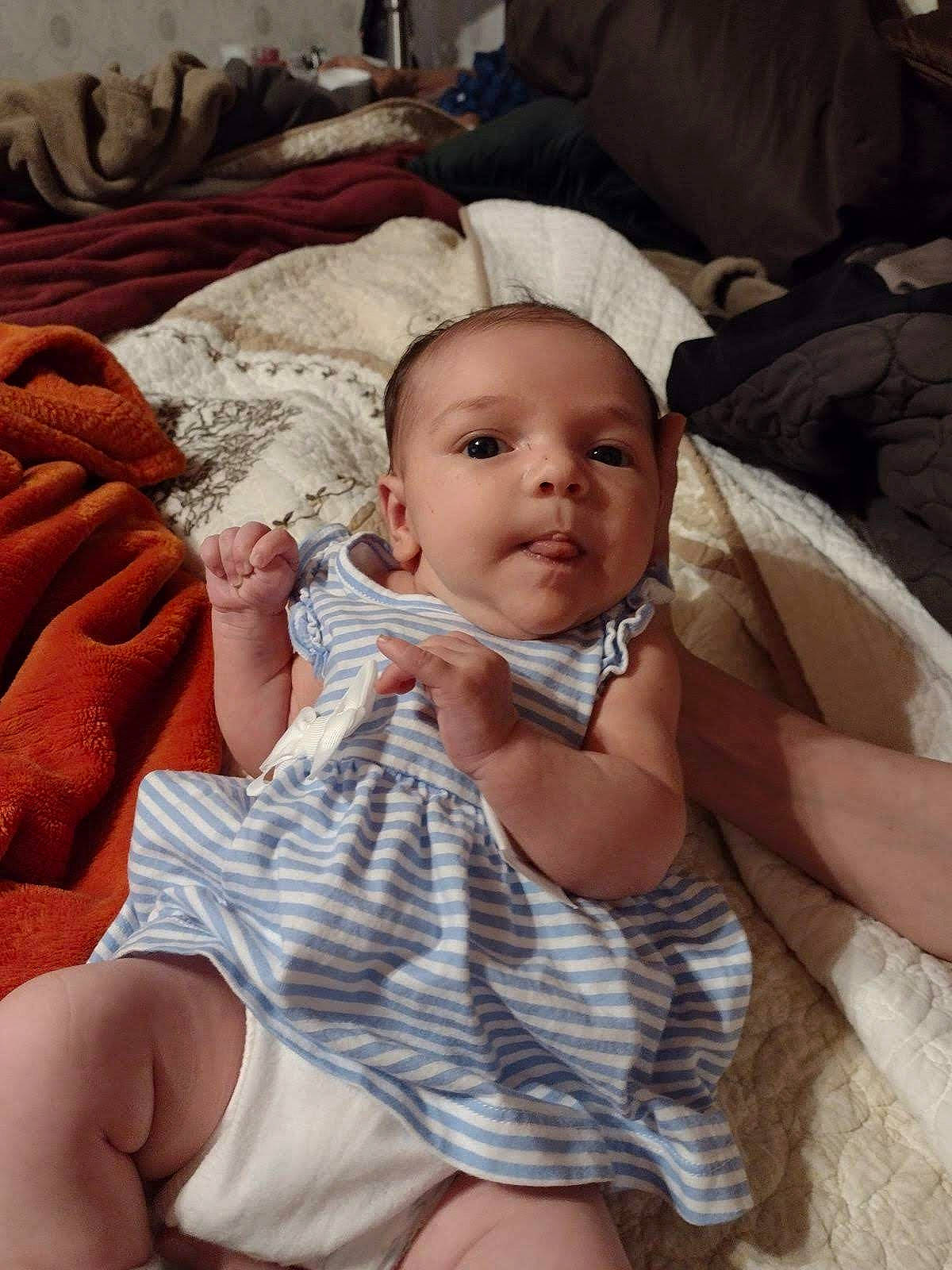 Robyn is registered to the contest to win money with this photo: abdomen, baby, baby_toddler_clothing, cheek, chest, child, comfort, foot, human_leg, lap, linens, nail, pattern, person, sitting, skin, sock, thigh, thumb, toddler