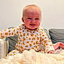 baby, blanket, child, clothing, couch, cozy, cute, face, floral, furniture, happy, head, indoors, infant, pattern, person, seated, smiling, soft, warm