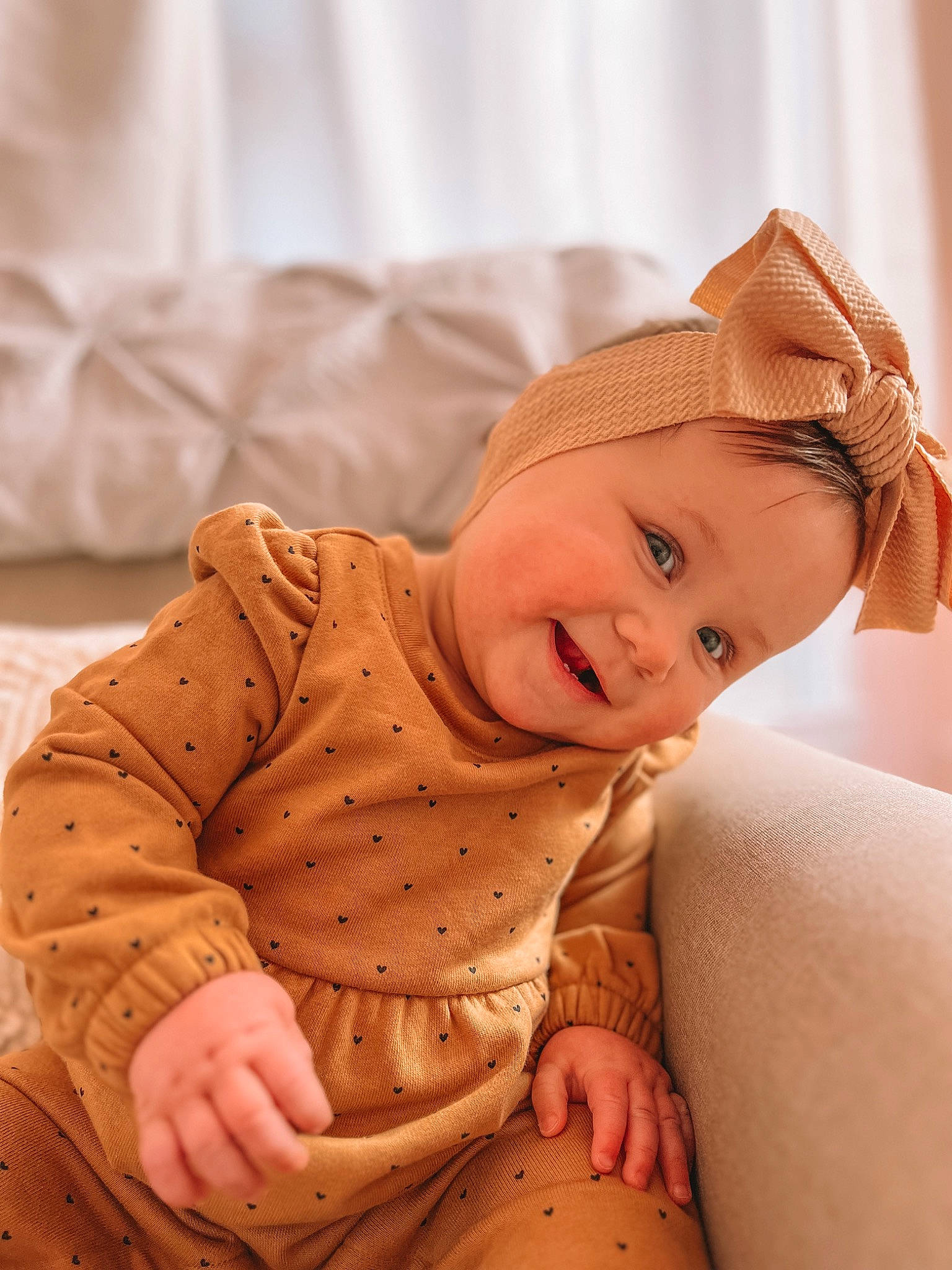 Oakley Rae joined the competition — help win amazing prizes! baby, baby_toddler_clothing, cheek, child, comfort, eye, fashion_accessory, flooring, happy, headgear, headwear, human_body, human_leg, pattern, peach, person, sitting, skin, sleeve, smile