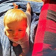 Malachi Brown is registered to the contest to win money with this photo: baby, child, tummy, blanket, blue_blanket, sunlight, outdoor, red_checkered, fabric, hand, face, head, skin, clothing, infant, expression, young_child, person, daylight, resting