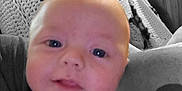 Malachi Brown is registered to the contest to win money with this photo: baby, blanket, blue_eyes, casual, child, close_up, clothing, couch, cozy, crochet, face, home, indoor, infant, person, portrait, red_hair, smiling, wood_paneling, young_child