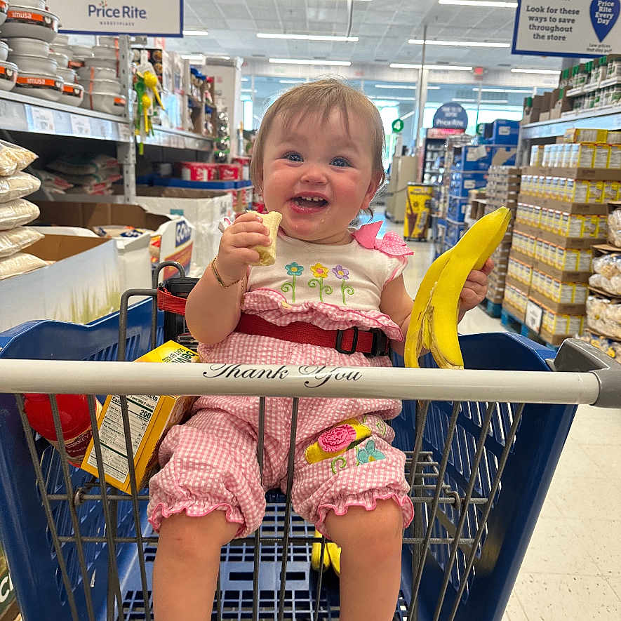 Zoey is registered to the contest to win money with this photo: accessories, baby, bodypart, bracelet, clothing, face, finger, footwear, hand, head, indoors, market, person, photography, portrait, shelf, shoe, shop, shoppingcart, shorts