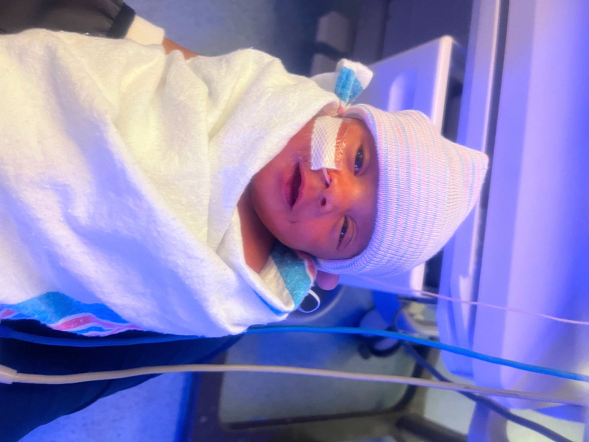 Paris is registered to the contest to win money with this photo: baby, child, childbirth, electric_blue, event, fun, hat, headwear, hospital, magenta, medical_equipment, person, purple, room, service, smile, toddler, water