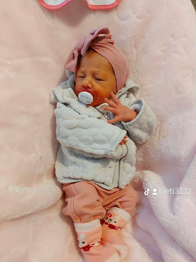 Kyara participe au concours pour gagner de l'argent avec cette photo : baby, baby_products, baby_safety, baby_sleeping, baby_toddler_clothing, bedding, bedtime, child, comfort, finger, happy, headwear, linens, peach, person, pink, sitting, sleeve, textile, thumb