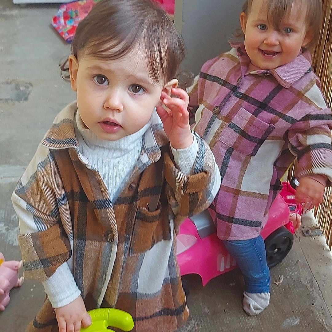 Kyara Zarah a rejoint le concours — aidez-le/la à gagner de superbes lots ! child, clothing, concrete, curious, cute, floor, fun, happy, indoor, jeans, person, pink, plaid_shirt, play, short_hair, smile, socks, steering_wheel, toddler, toy_car