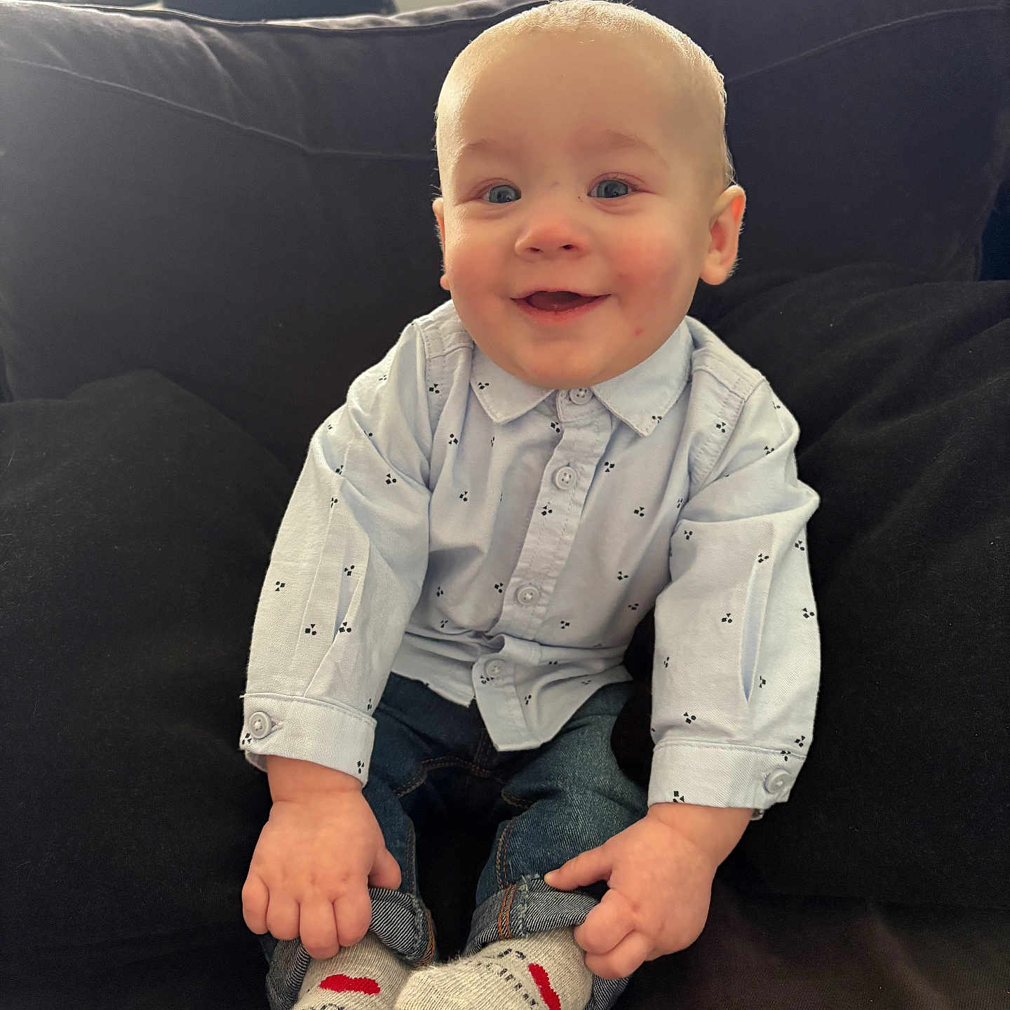 Maëlo participe au concours pour gagner de l'argent avec cette photo : baby, black_cushion, blue_shirt, casual_clothing, child, couch, cute, face, happy, home, indoor, infant, jeans, light, portrait, sitting, small_hands, smiling, socks, window