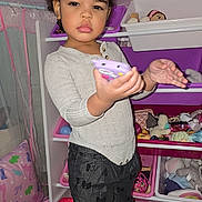 Sᴀᴇʟʟᴇᴍ joined the competition — help win amazing prizes! child, toddler, portrait, standing, indoors, playroom, toy_storage, toys, stuffed_animals, doll, purple, pink, hair_bows, gray_sweater, black_pants, socks, smartphone, focused, bedroom, rug