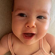 Esperanza participe au concours pour gagner de l'argent avec cette photo : baby, beige, bright_eyes, child, chubby_cheeks, close_up, curious, cute, face, happy, indoor, infant, joyful, lying_down, peach_outfit, portrait, skin, sleeveless, smiling, texture