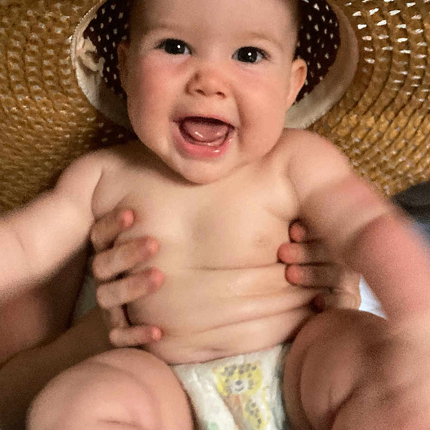 Esperanza participe au concours pour gagner de l'argent avec cette photo : baby, child, chubby, cute, diaper, expression, face, feet, hands, happy, hat, headwear, holding, indoor, infant, person, playful, skin, smiling, straw_hat