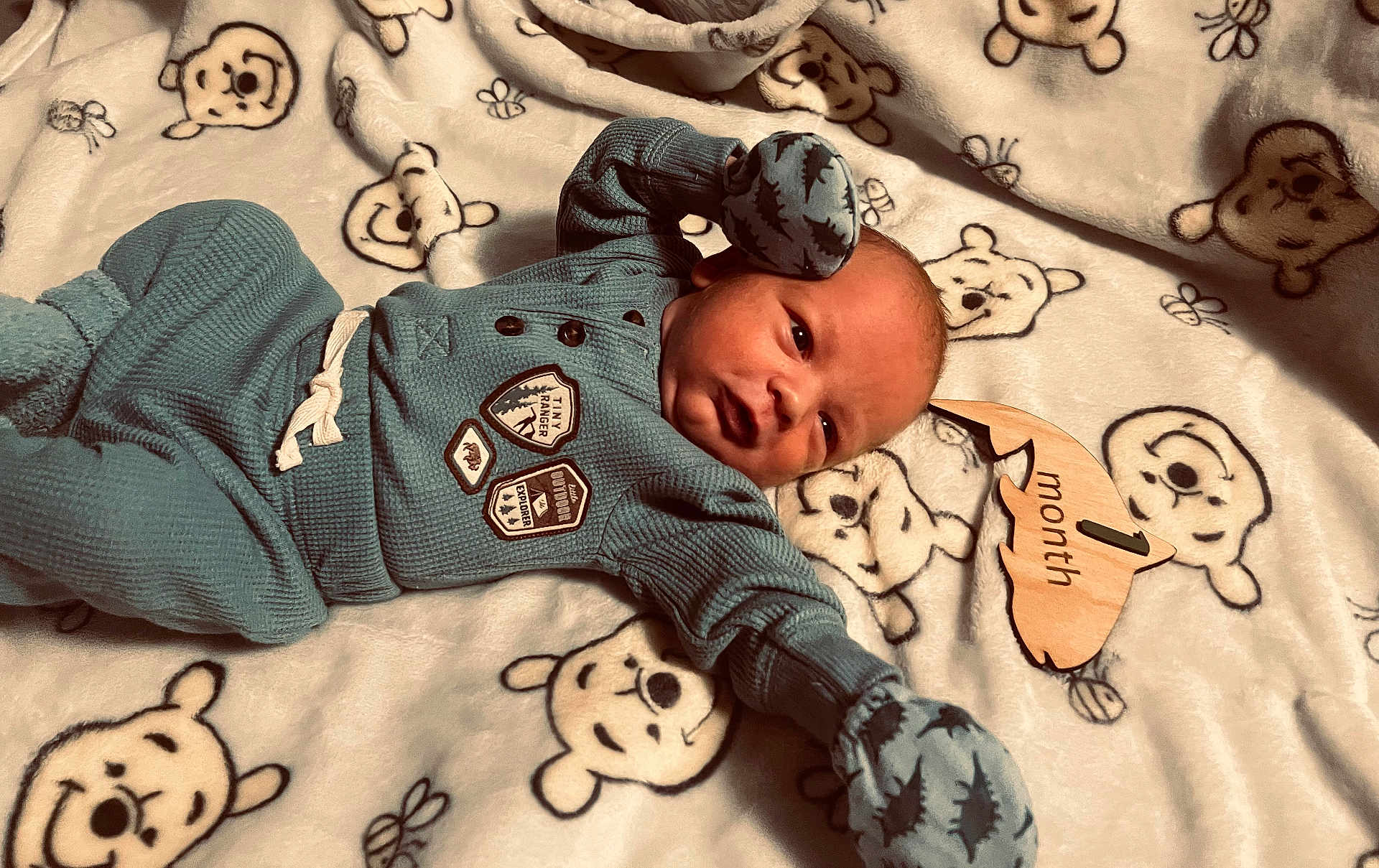 Gavin joined the competition — help win amazing prizes! baby, newborn, infant, blue_clothing, mittens, blanket, bear_pattern, wooden_sign, one_month, lying_down, cute, cozy, soft_texture, milestone, portrait, child, face, sleepwear, baby_clothes, indoors