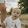 Kasen is registered to the contest to win money with this photo: adult, baby, bokeh, child, curious, eyes, face, golden_hour, hand, infant, nature, outdoor, parent, portrait, reflection, river, sitting, trees, water, white_outfit