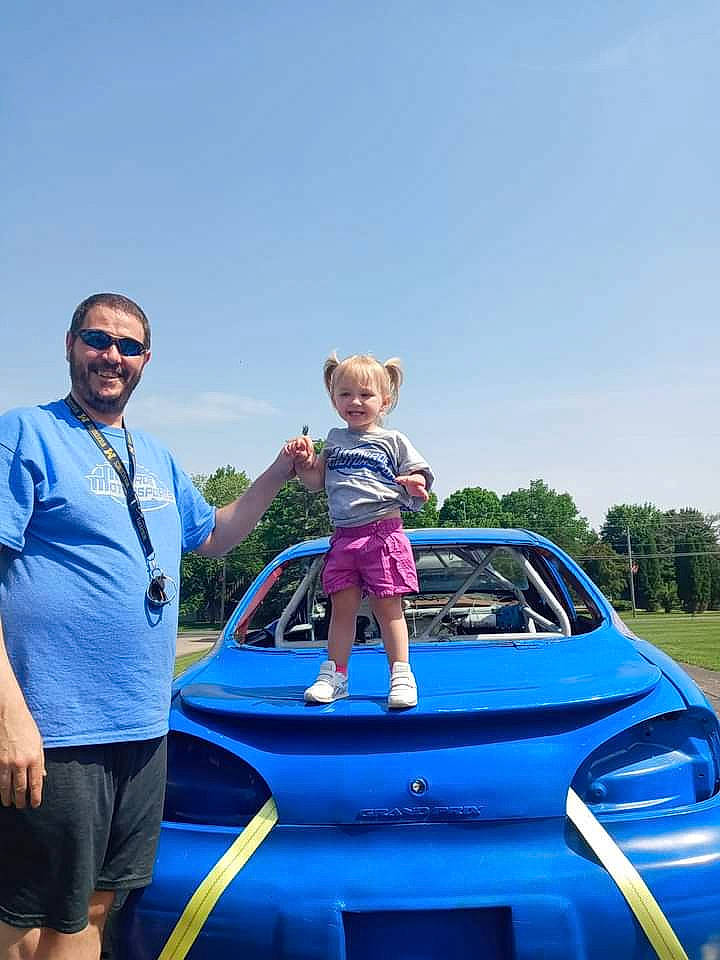 Brooke joined the competition — help win amazing prizes! automotive_design, automotive_exterior, automotive_lighting, blue, bumper, car, electric_blue, fun, hood, joy, leisure, motor_vehicle, person, recreation, shorts, sky, summer, sunglasses, toddler, travel