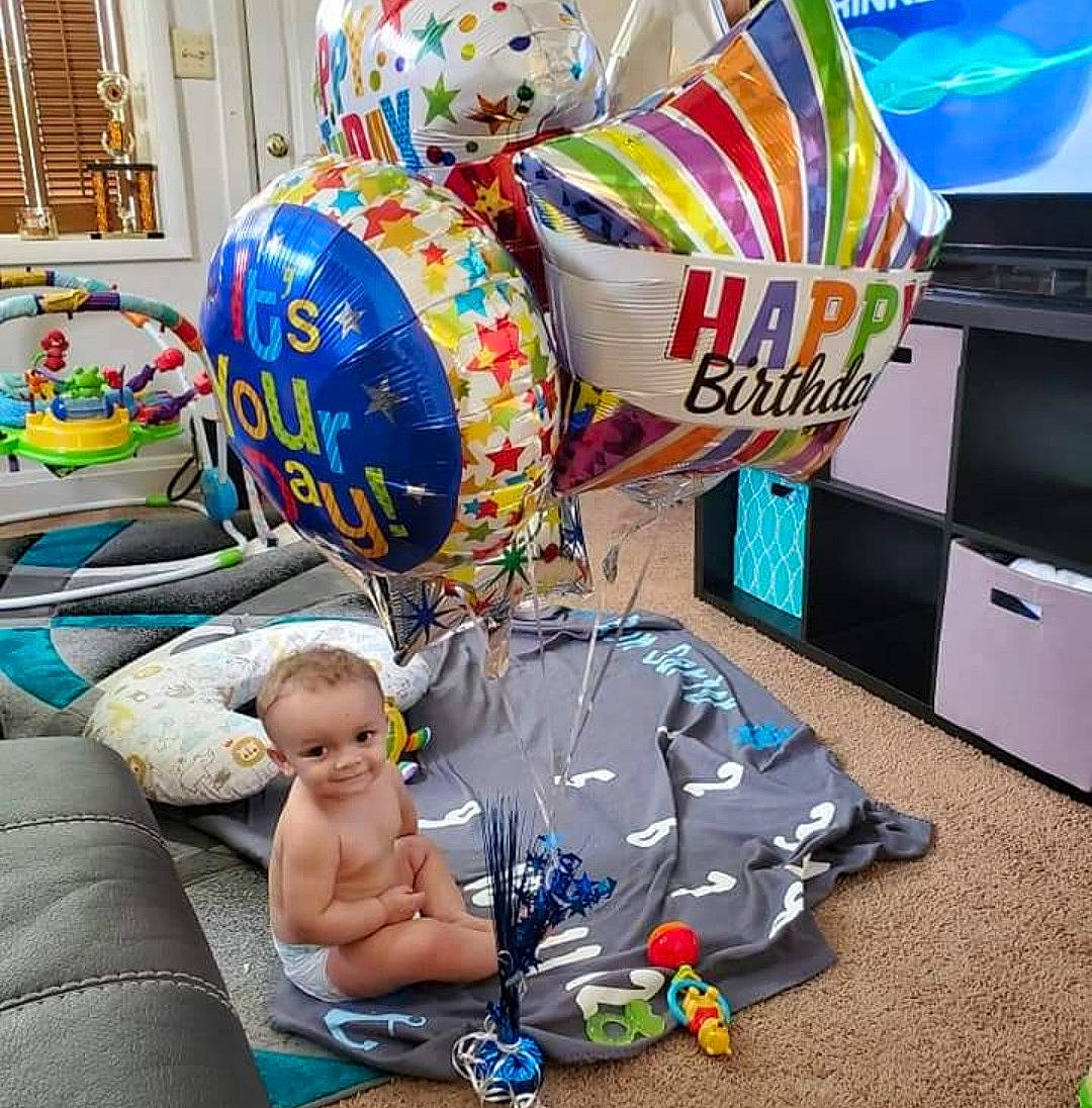 Jaxon is registered to the contest to win money with this photo: art, baby, baby_products, baby_toddler_clothing, balloon, child, event, fun, holiday, inflatable, joy, leisure, party_supply, person, play, sitting, stuffed_toy, textile, toddler, toy