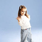 Sofia is registered to the contest to win money with this photo: blue_background, casual_clothing, child, cute, fashion, footwear, full_body, girl, hair_clip, happy, innocent, jeans, playful, portrait, posing, smiling, standing, studio, white_blouse, young