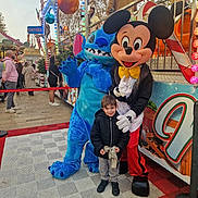 Matthias participe au concours pour gagner de l'argent avec cette photo : amusement_park, boy, celebration, character, child, costume, crowd, entertainment, event, family, festival, fun, holiday_decorations, lights, mickey_mouse, outdoor, people, smile, stitch, winter_clothing