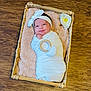 Camila is registered to the contest to win money with this photo: baby, newborn, swaddle, headband, basket, blanket, wooden_floor, flower, infant, cute, sleeping, soft_texture, indoor, portrait, child, wrapped, peaceful, resting, adorable, person