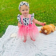 Memphis Carpenter is registered to the contest to win money with this photo: baby, clothing, costume, dress, face, flower, grass, hat, head, lawn, nature, outdoors, park, person, petal, photography, plant, portrait, sitting, summer