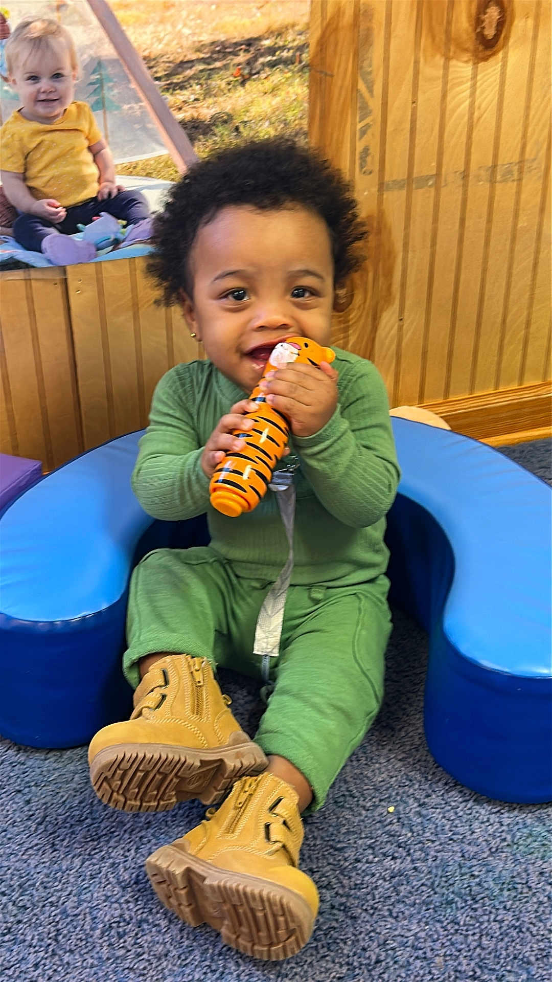Dreayden joined the competition — help win amazing prizes! toddler, baby, child, toy, green_clothing, yellow_shirt, boots, blue_cushion, carpet, wood_paneling, smiling, indoor, playtime, cute, happy, people, face, sitting, window, background
