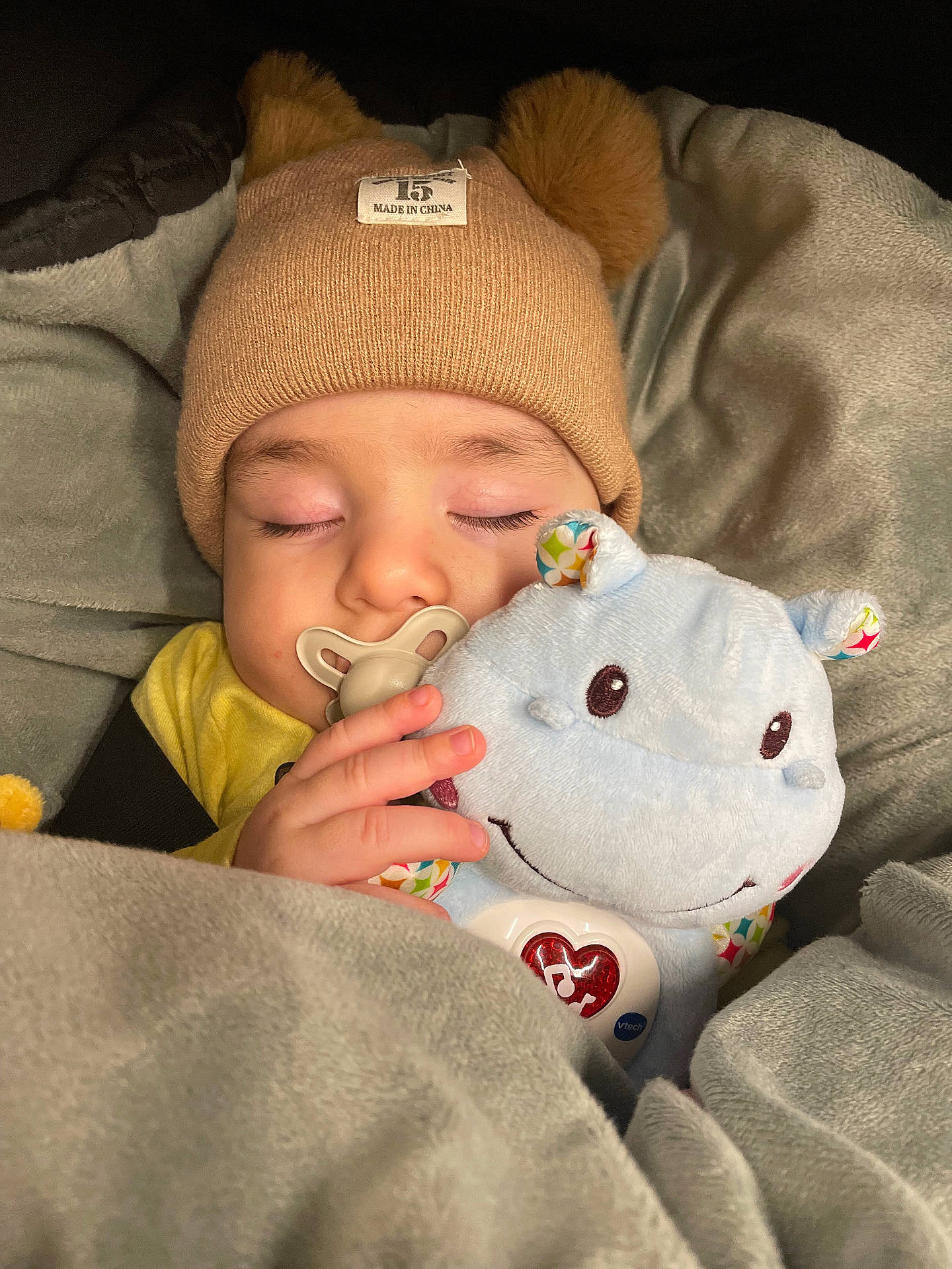 baby, beanie, blanket, bodypart, bonnet, cap, clothing, couch, face, finger, furniture, hand, hat, head, newborn, person, photography, portrait, sleeping, toy
