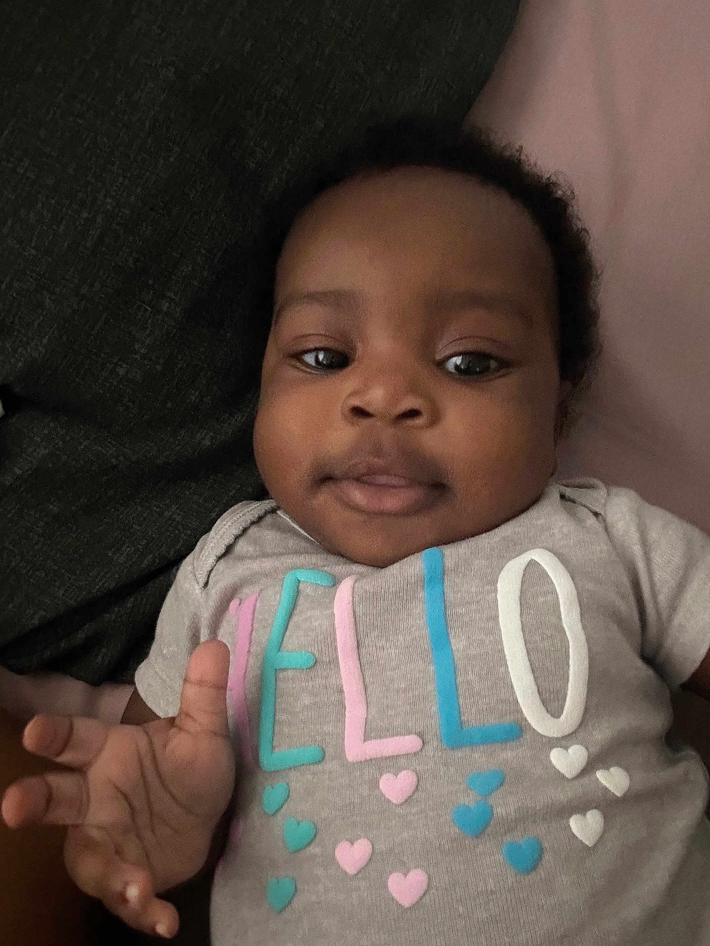 Ivanna joined the competition — help win amazing prizes! baby, infant, child, face, hand, clothing, shirt, letters, hearts, lying_down, cute, skin, person, portrait, indoors, expression, looking, young, casual, soft