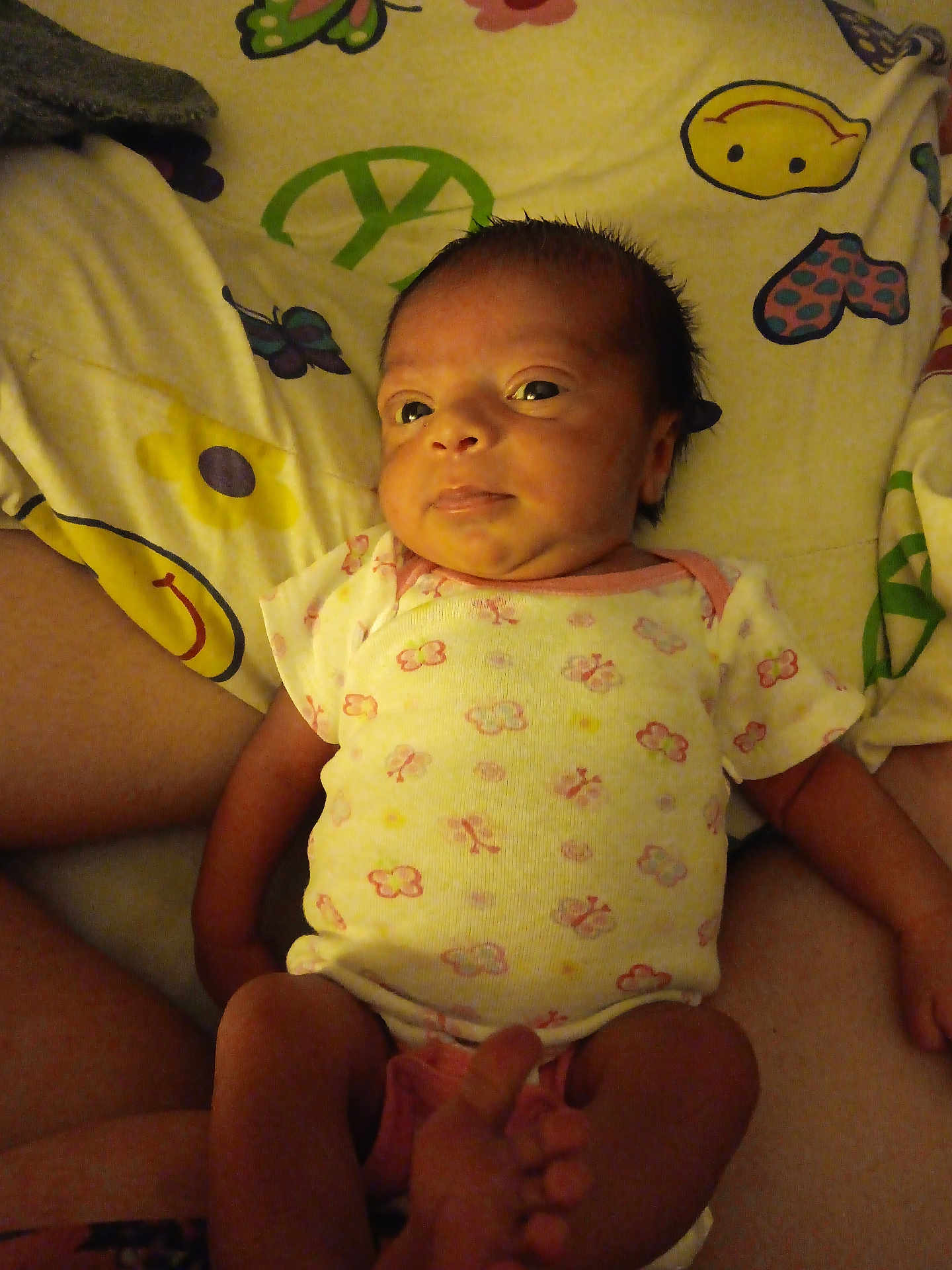 Serenity joined the competition — help win amazing prizes! baby, infant, newborn, onesie, blanket, butterfly, smiley_face, pattern, cute, child, person, skin, lying_down, indoors, soft_lighting, hand, feet, expression, warm_tone, cozy