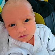 Damian joined the competition — help win amazing prizes! baby, newborn, infant, face, eyes, onesie, clothing, white, penguin_pattern, closeup, portrait, soft_texture, indoor, person, cute, newborn_baby, head, skin, expression, small