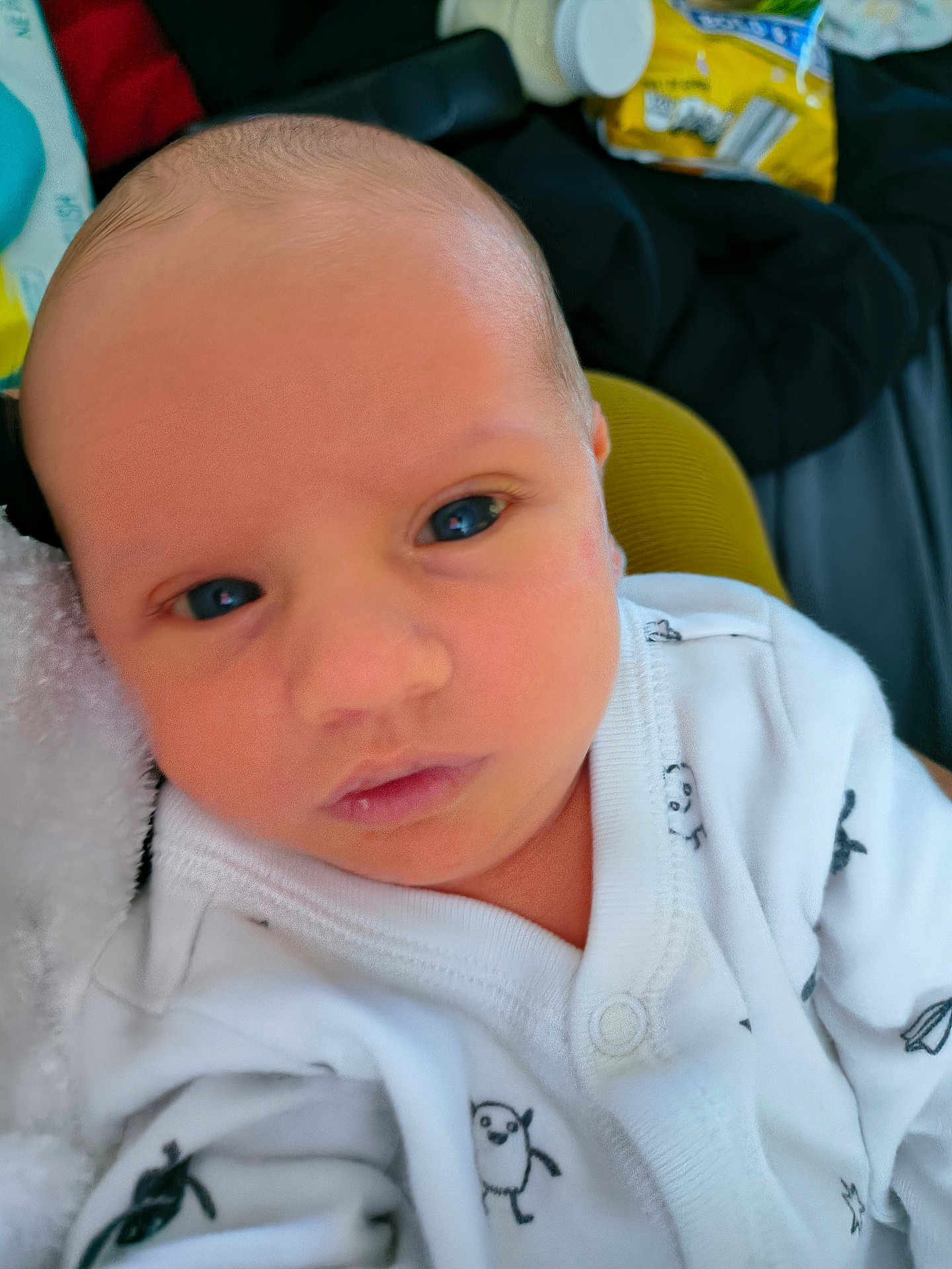 Damian joined the competition — help win amazing prizes! baby, newborn, infant, face, eyes, onesie, clothing, white, penguin_pattern, closeup, portrait, soft_texture, indoor, person, cute, newborn_baby, head, skin, expression, small