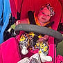 baby, stroller, child, smile, headband, clothing, sock, pacifier, seatbelt, fabric, pattern, pink, yellow, black, white, outdoor, sunlight, cute, infant, comfort