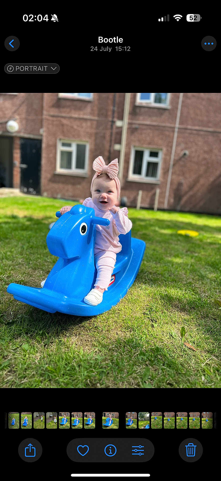 Ada-Jane joined the competition — help win amazing prizes! baby, blue_toy, bow, building, child, daylight, fun, grass, grass_field, greenery, happy, headband, outdoor, person, pink_clothing, playtime, rocking_horse, smiling, toy, window
