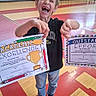 child, boy, young, laughing, smiling, face, portrait, certificates, award, achievement, academic, excellence, effort, school, gymnasium, indoor, sports_hall, wooden_floor, casual_clothing, sneakers