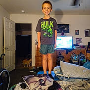 Charles joined the competition — help win amazing prizes! child, boy, smiling, standing, indoors, bedroom, hulk_shirt, superhero, television, dresser, blankets, pillows, backpacks, cat, door, ceiling_fan, furniture, portrait, home, cozy