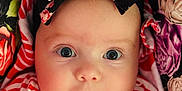 Evelyn is registered to the contest to win money with this photo: baby, child, face, headband, bow, striped_clothing, red_and_white, floral_pattern, close_up, portrait, cute, innocent, eyes, infant, soft_lighting, fabric, colorful, pattern, person, young