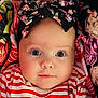 baby, child, face, headband, bow, striped_clothing, red_and_white, floral_pattern, close_up, portrait, cute, innocent, eyes, infant, soft_lighting, fabric, colorful, pattern, person, young