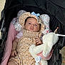 baby, infant, stroller, stuffed_animal, bunny, hat, romper, pink_blanket, cushion, outdoor, child, cute, portrait, clothing, toy, person, baby_girl, face, baby_hat, soft_toy