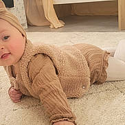 Elynn participe au concours pour gagner de l'argent avec cette photo : baby, child, infant, headband, beige_clothing, white_tights, soft_rug, indoor, floor, cute, smiling, crawling, warm_lighting, cozy, portrait, young_child, furniture, home, playful, happy
